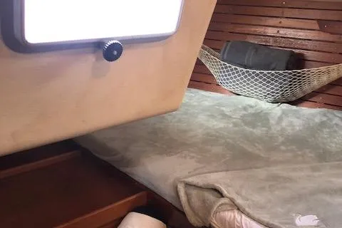 Slide: The Image of Cozy cabin interior of 1981 Nautor Swan 371 Sloop with wooden paneling and hammock storage. - 8