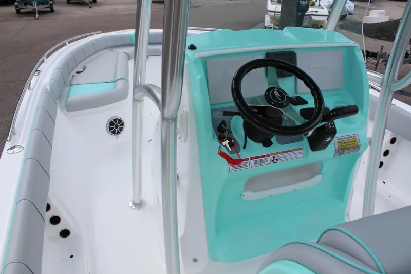 Slide: The Image of 2022 ALK2 Powerboats 25 CRX center console with teal accents and steering wheel. - 11