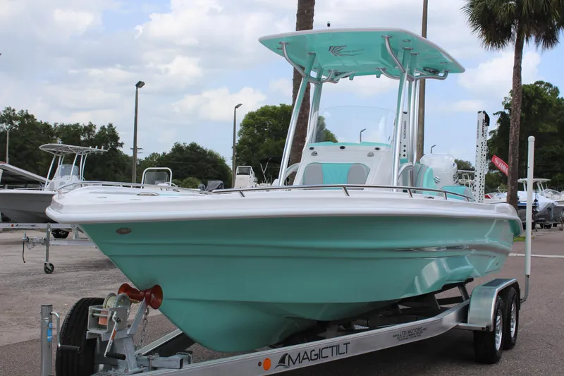 Slide: The Image of 2022 ALK2 Powerboats 25 CRX on trailer, teal and white, parked outdoors. - 3