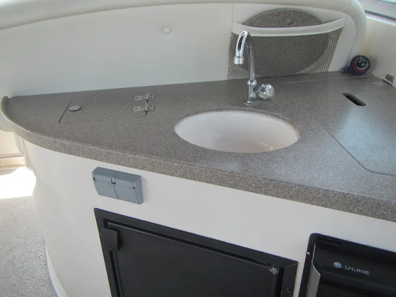 Slide: The Image of 2004 Rinker 342 Express Cruiser kitchenette with sink and storage compartments. - 24