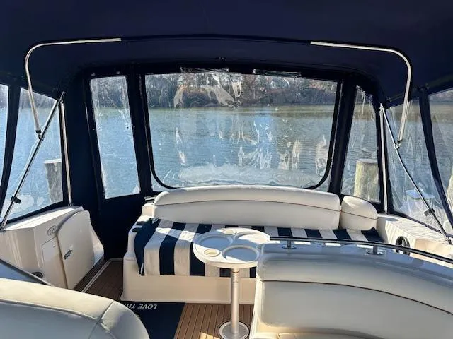 Slide: The Image of 2004 Rinker 342 Express Cruiser interior with striped seating and water view. - 25