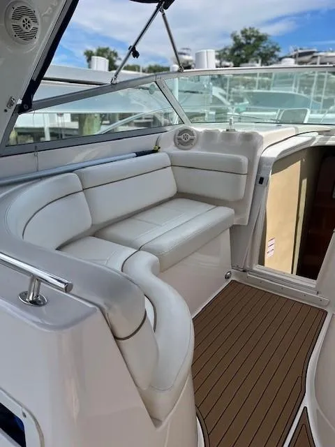Slide: The Image of 2004 Rinker 342 Express Cruiser interior with white seating and wood flooring. - 28
