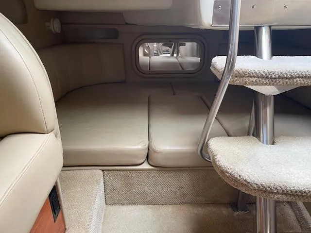 Slide: The Image of 2004 Rinker 342 Express Cruiser cabin interior with beige seating and carpeted stairs. - 29