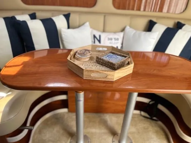 Slide: The Image of 2004 Rinker 342 Express Cruiser interior with wooden table and nautical-themed decor. - 31