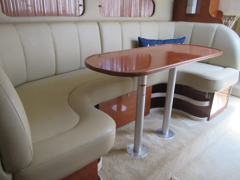 Slide: The Image of 2004 Rinker 342 Express Cruiser interior with beige seating and wooden table. - 33
