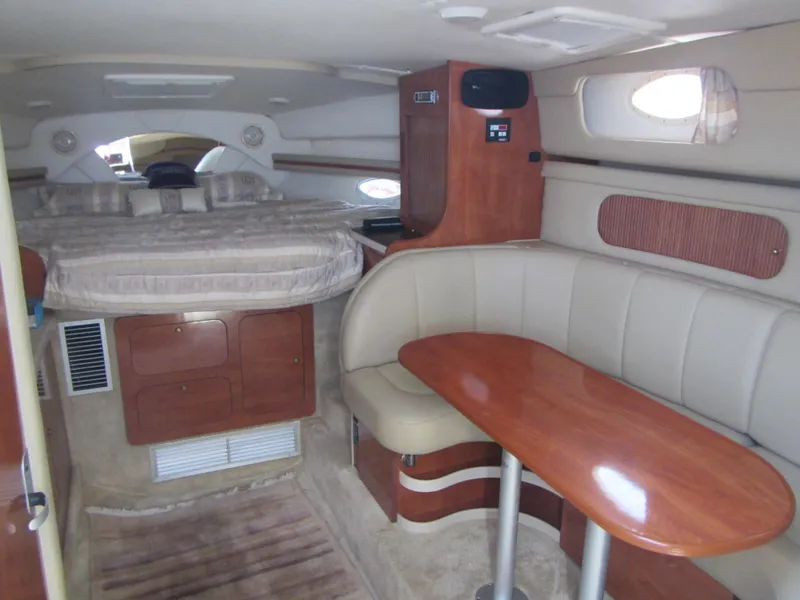 Slide: The Image of 2004 Rinker 342 Express Cruiser interior with bed, seating, and wooden table. - 35