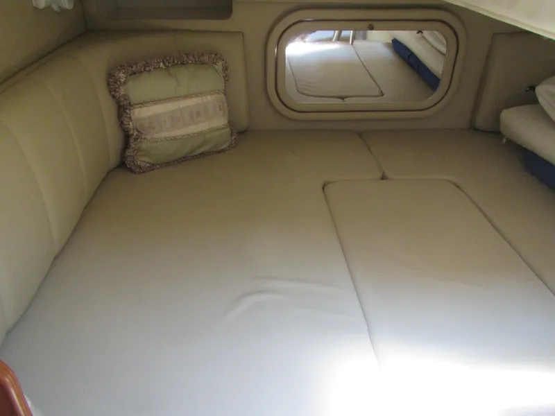Slide: The Image of 2004 Rinker 342 Express Cruiser cabin interior with beige upholstery and decorative pillow. - 37