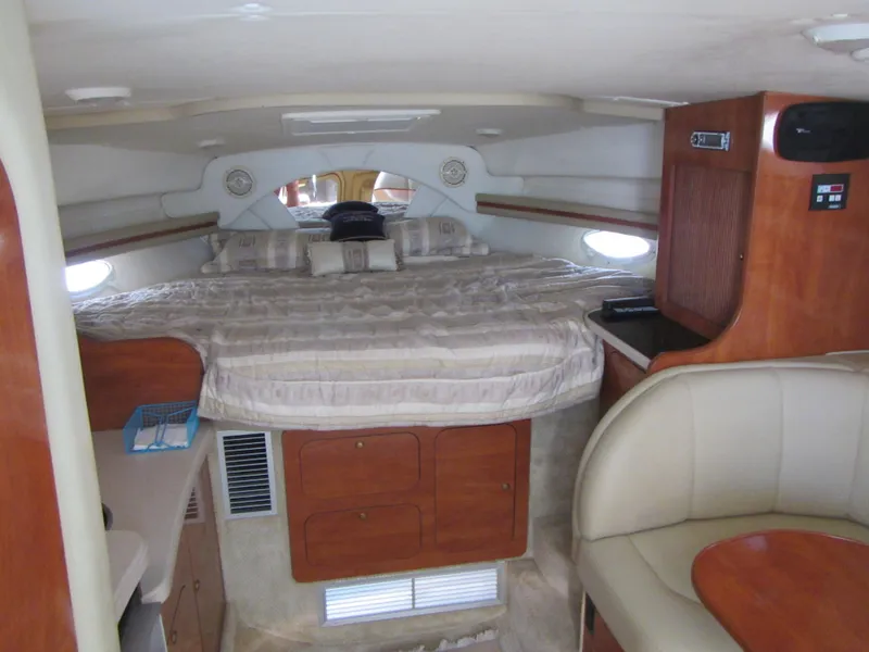 Slide: The Image of 2004 Rinker 342 Express Cruiser interior with bed, wood cabinetry, and seating area. - 41