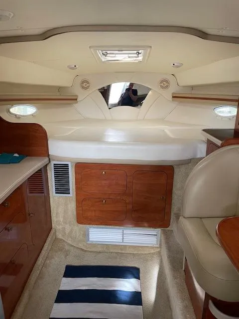 Slide: The Image of Interior of 2004 Rinker 342 Express Cruiser with wood cabinetry and striped rug. - 42