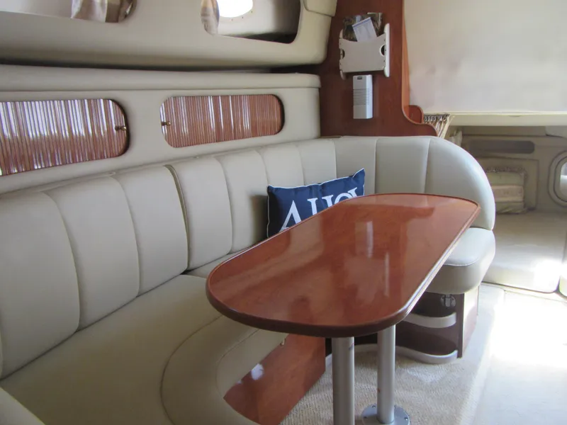 Slide: The Image of 2004 Rinker 342 Express Cruiser interior with beige seating and wooden table. - 46