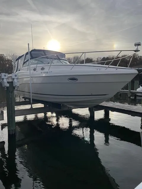 Slide: The Image of 2004 Rinker 342 Express Cruiser on lift at sunset, reflecting on water. - 5
