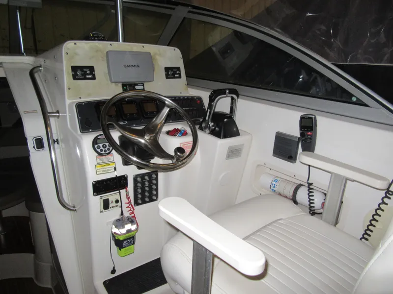 Slide: The Image of 2002 Boston Whaler 295 Conquest helm with steering wheel and navigation equipment. - 13