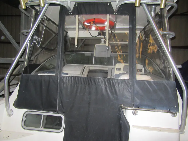 Slide: The Image of 2002 Boston Whaler 295 Conquest boat cockpit with black canvas cover and life preserver. - 17