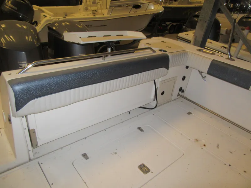Slide: The Image of 2002 Boston Whaler 295 Conquest boat interior with cushioned seating and storage compartments. - 20