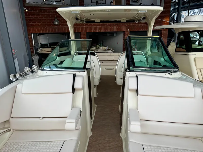 Slide: The Image of 2023 Chris-Craft Launch 31 GT boat interior with white seating and glass windshields. - 13