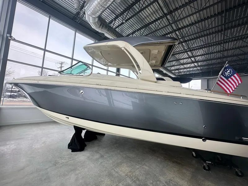 Slide: The Image of 2023 Chris-Craft Launch 31 GT boat in showroom with American flag. - 5