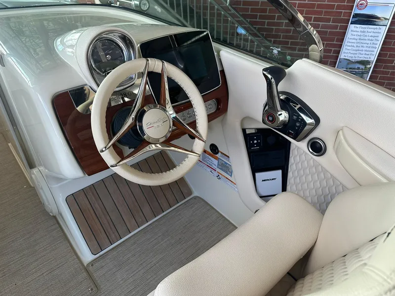 Slide: The Image of 2024 Chris-Craft Launch 28 GT boat cockpit with steering wheel and control panel. - 12