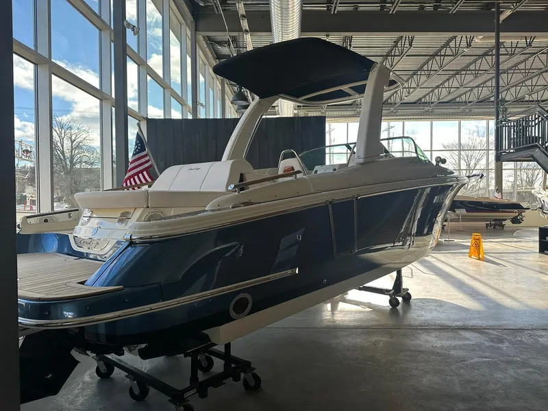Slide: The Image of 2024 Chris-Craft Launch 28 GT boat displayed indoors with American flag. - 5