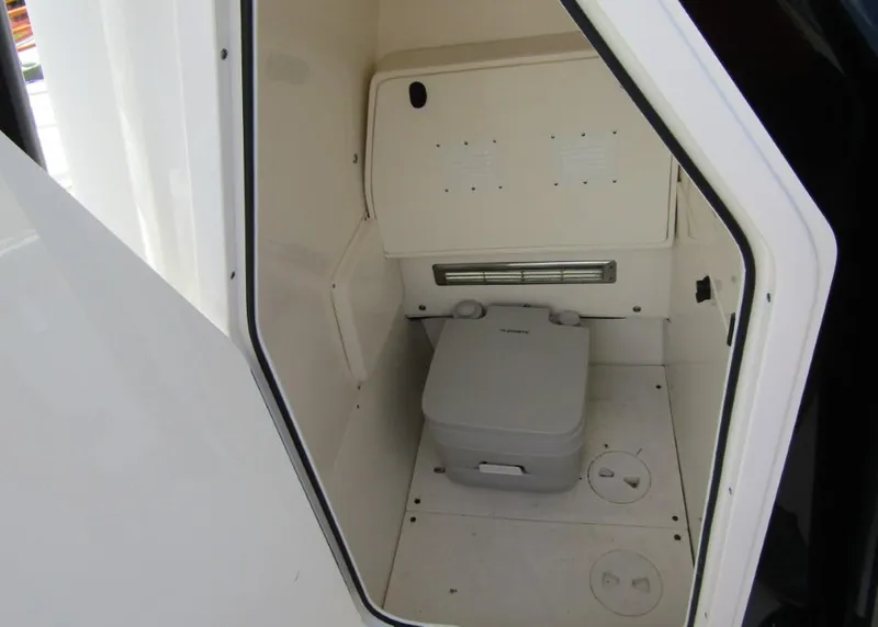 Slide: The Image of 2021 ShearWater 250 Carolina Bay boat interior with portable toilet. - 12