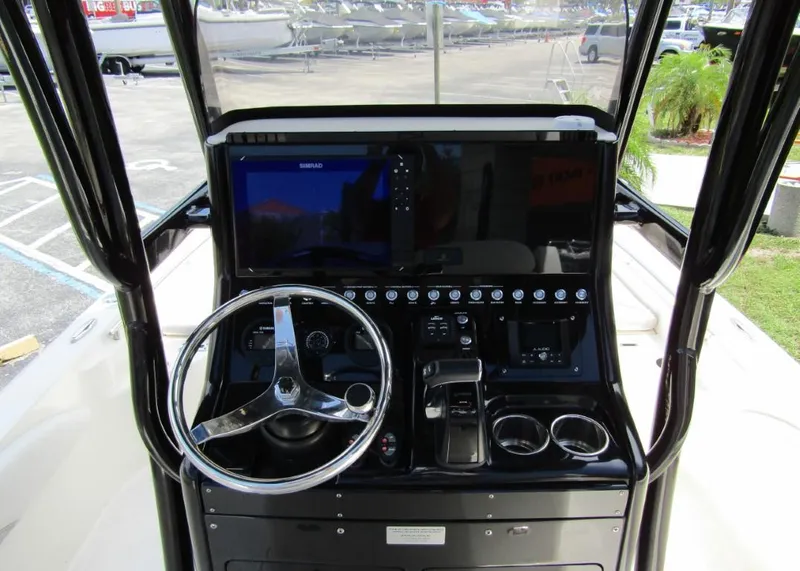 Slide: The Image of 2021 ShearWater 250 Carolina Bay boat console with steering wheel and controls. - 14