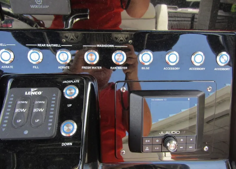 Slide: The Image of Control panel of a 2021 ShearWater 250 Carolina Bay boat with various switches and JL Audio system. - 17
