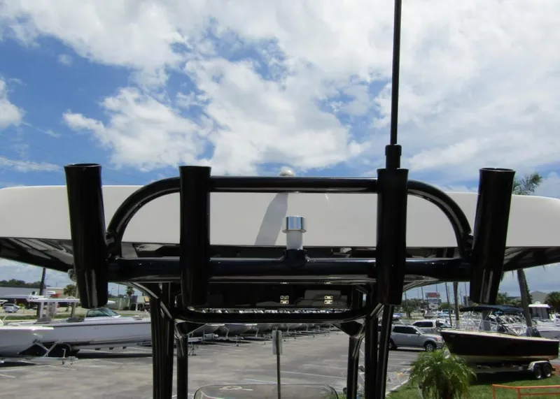 Slide: The Image of 2021 ShearWater 250 Carolina Bay boat with rod holders and T-top against a cloudy sky. - 28