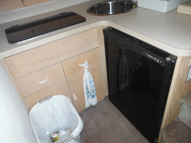 Slide: The Image of 1990 Silverton 34 Convertible boat kitchen with sink, stove, and mini-fridge. - 14