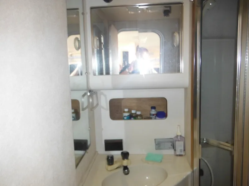 Slide: The Image of 1990 Silverton 34 Convertible bathroom with sink, mirror, and shower. - 17