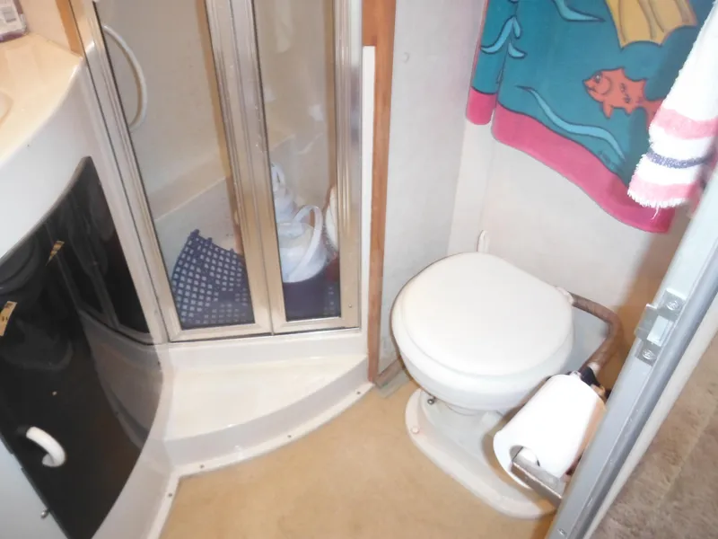 Slide: The Image of 1990 Silverton 34 Convertible bathroom with shower, toilet, and sink. - 19