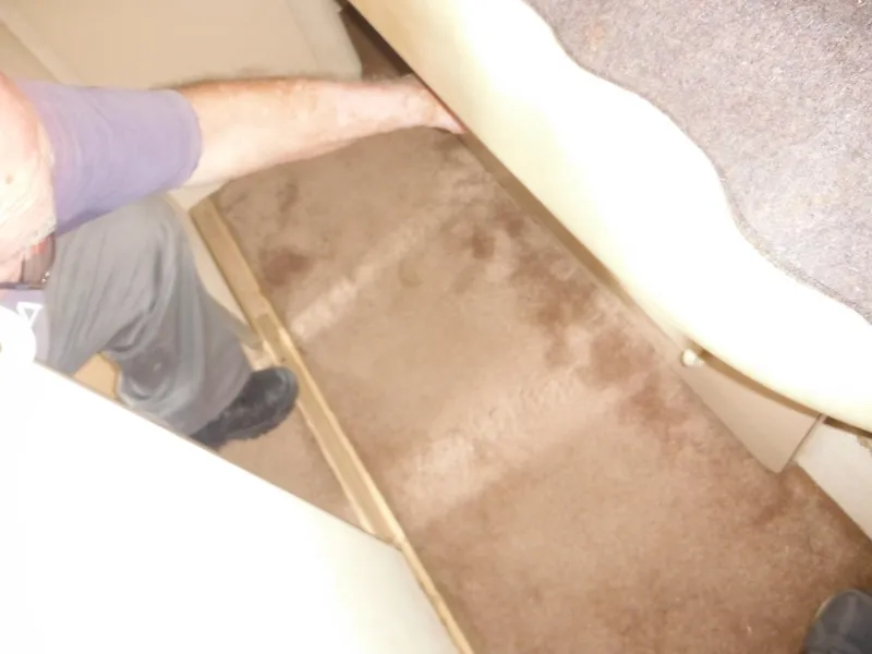 Slide: The Image of Man inspecting carpeted interior of 1990 Silverton 34 Convertible boat. - 28