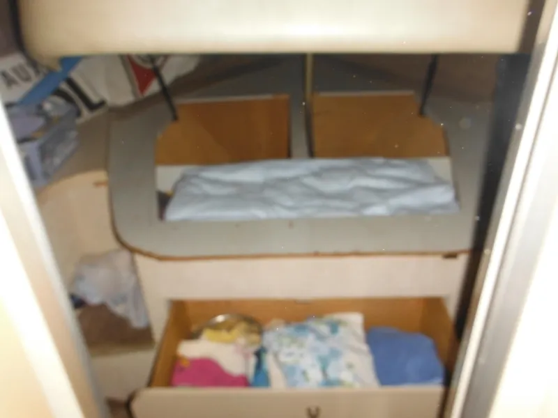 Slide: The Image of Interior cabin of a 1990 Silverton 34 Convertible boat with bedding and storage. - 29