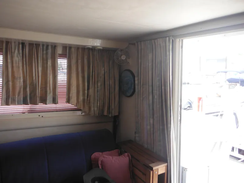 Slide: The Image of Interior of a 1990 Silverton 34 Convertible boat with curtains and seating area. - 34