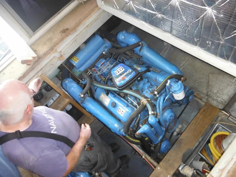 Slide: The Image of Man inspecting engine of 1990 Silverton 34 Convertible boat. - 46