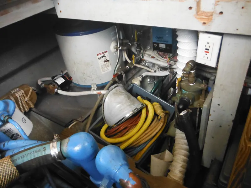Slide: The Image of Engine room of a 1990 Silverton 34 Convertible boat with various equipment and hoses. - 47