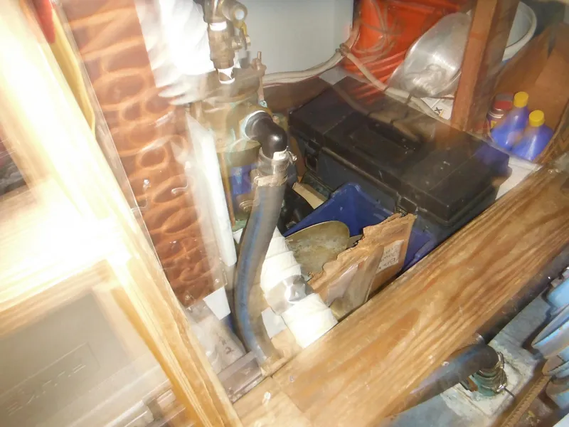 Slide: The Image of Engine compartment of a 1990 Silverton 34 Convertible boat with various components and tools. - 49