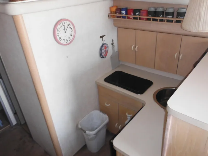 Slide: The Image of Compact kitchen area in a 1990 Silverton 34 Convertible boat with stove and cabinets. - 8