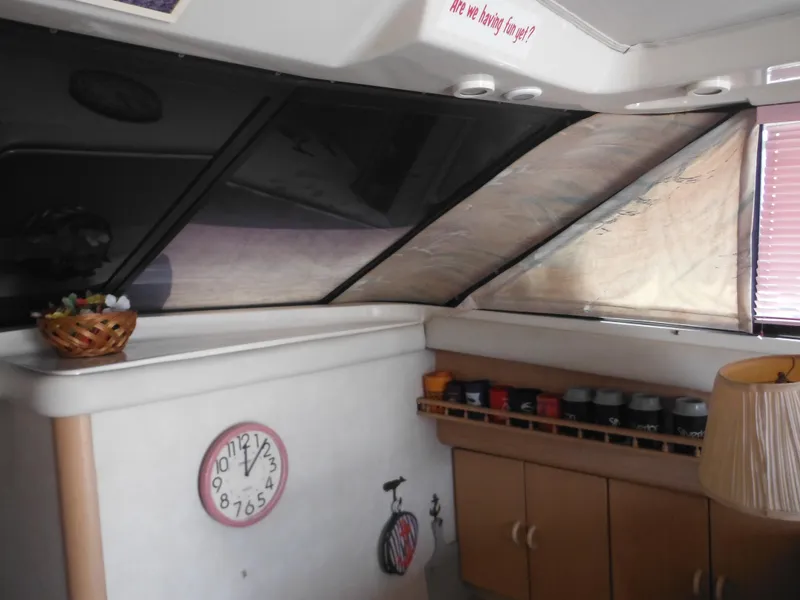 Slide: The Image of Interior of 1990 Silverton 34 Convertible boat with clock, cabinets, and windows. - 9