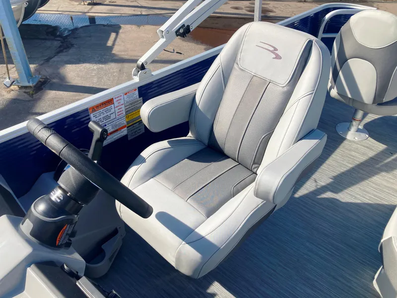 Slide: The Image of 2023 Bennington 22 SXSAPG boat captain's chair with steering wheel, featuring gray upholstery. - 6