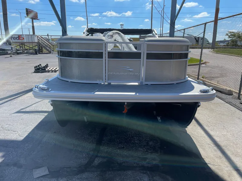 Slide: The Image of 2023 Bennington 22SXSR pontoon boat in a marina. - 2