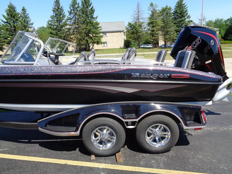Slide: The Image of 2023 Ranger 1880 MS Angler boat on a trailer in a parking lot. - 2