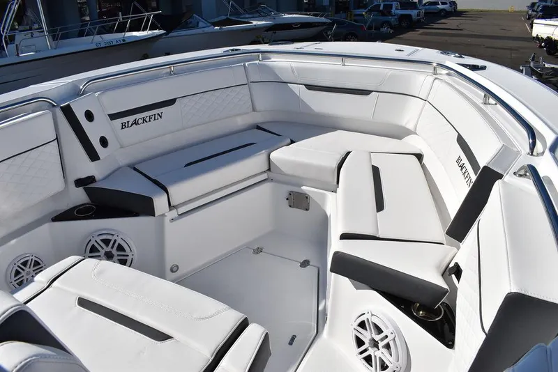 Slide: The Image of 2023 Blackfin 272CC boat interior with white cushioned seating and speakers. - 19