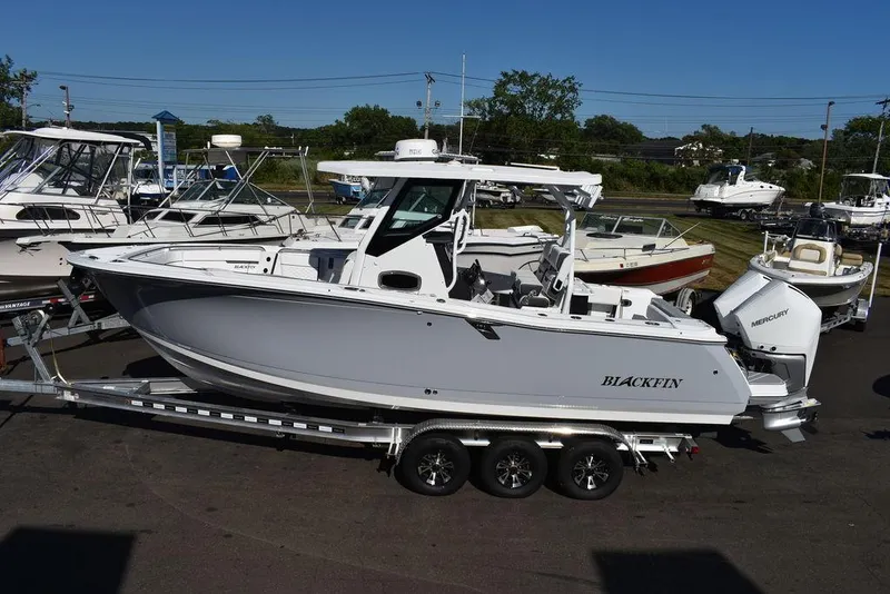 Slide: The Image of 2023 Blackfin 272CC boat on a trailer in a marina. - 3