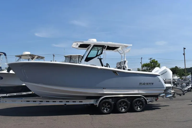Slide: The Image of 2023 Blackfin 272CC boat on a trailer in a parking lot. - 4
