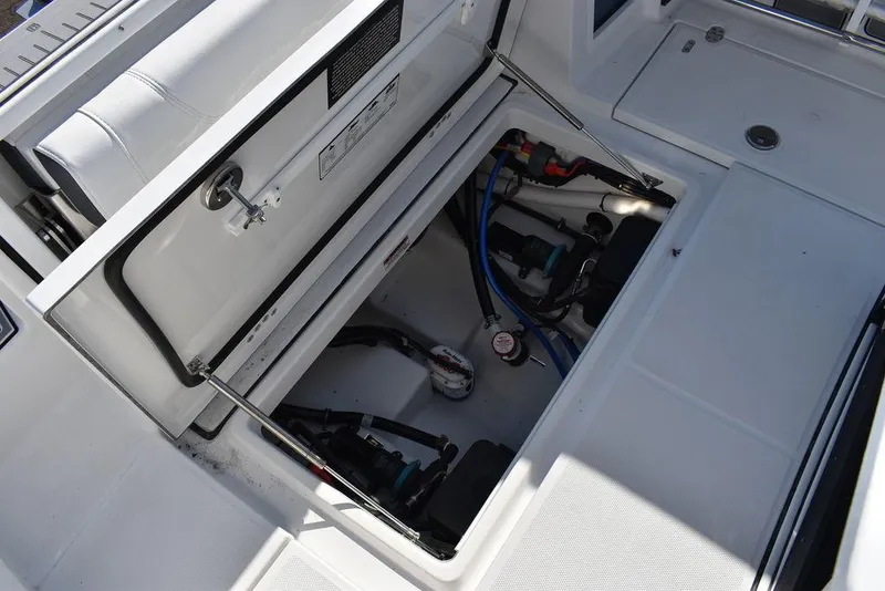 Slide: The Image of 2023 Blackfin 272CC boat storage compartment with open hatch and visible equipment. - 48