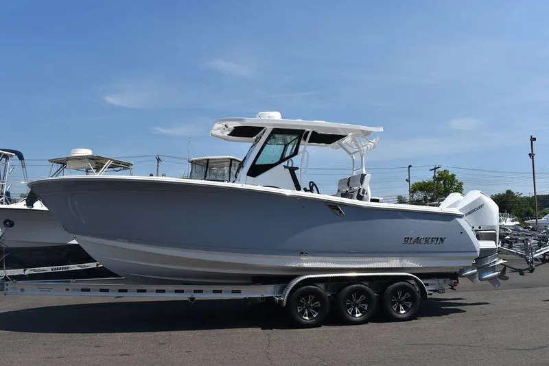 Slide: The Image of 2023 Blackfin 272CC boat on a trailer in a marina. - 5