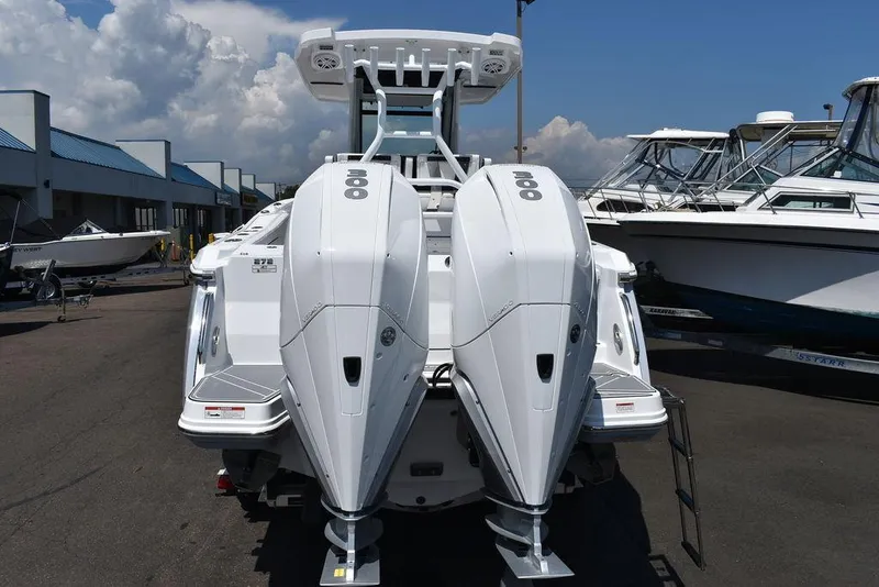 Slide: The Image of 2023 Blackfin 272CC boat with twin outboard engines, docked at a marina. - 6