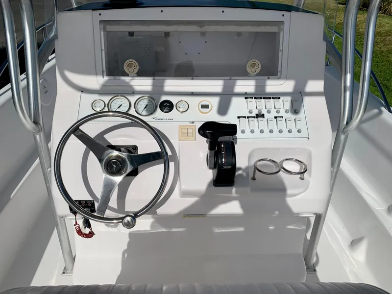 Slide: The Image of 2004 Pro-Line 25 Sport boat console with steering wheel, gauges, and controls. - 10