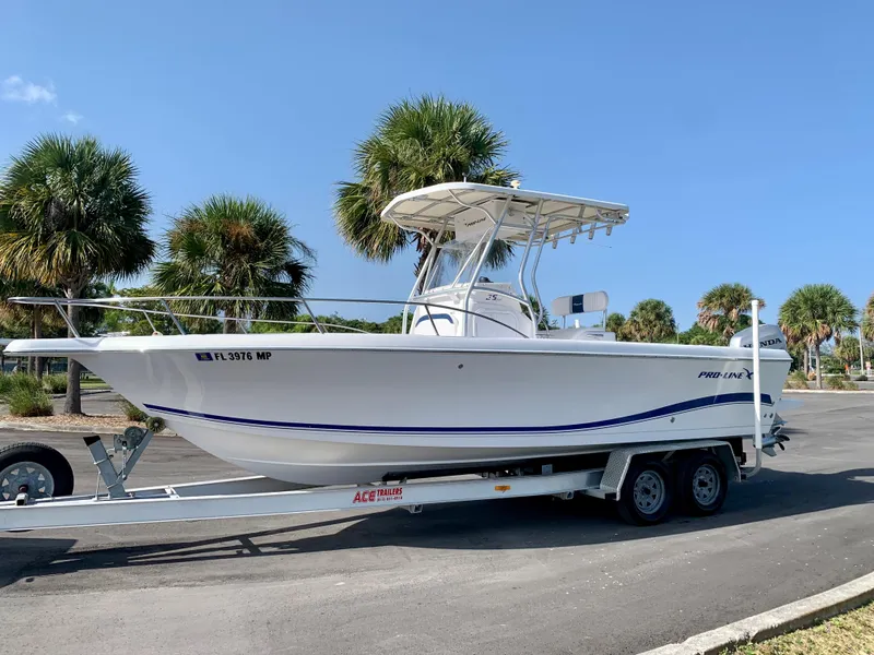 Slide: The Image of 2004 Pro-Line 25 Sport boat on trailer with palm trees in background. - 18