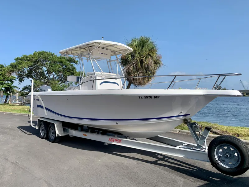 Slide: The Image of 2004 Pro-Line 25 Sport boat on a trailer by the waterfront. - 20