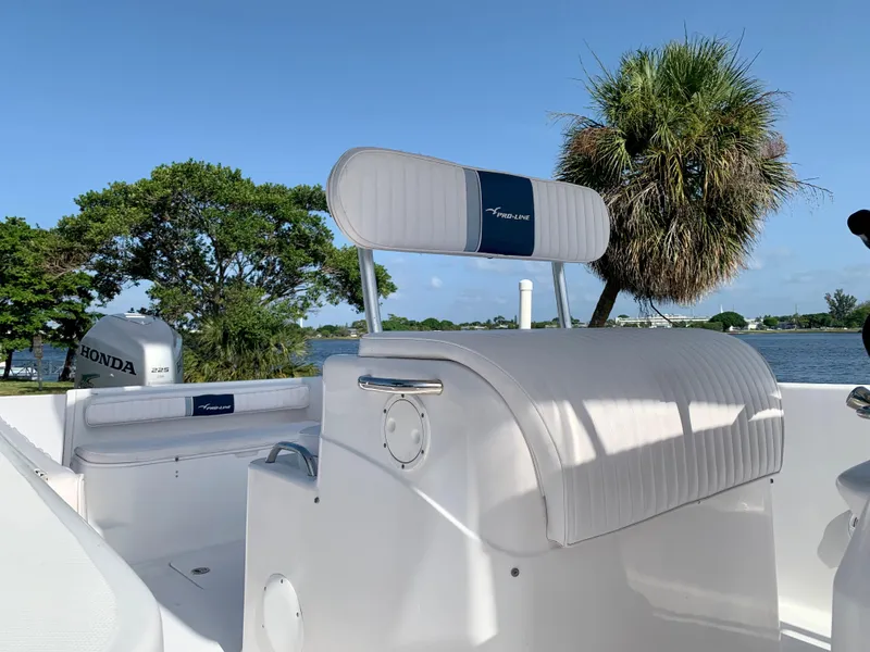 Slide: The Image of 2004 Pro-Line 25 Sport boat with Honda outboard motor, scenic water and palm tree background. - 21